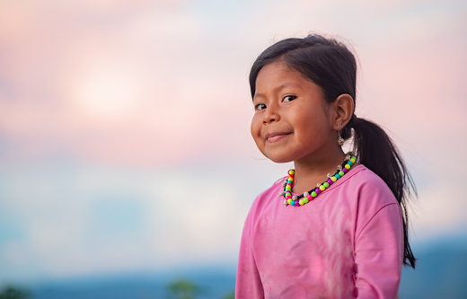 portrait of little indigenous girl playing outdoors smiling happy