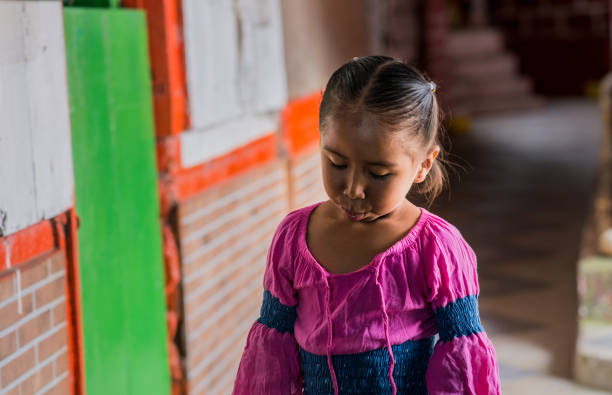 little girl walking down a corridor in the open air while looking to the side