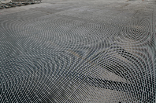 Open steel grating for a rooftop floor.