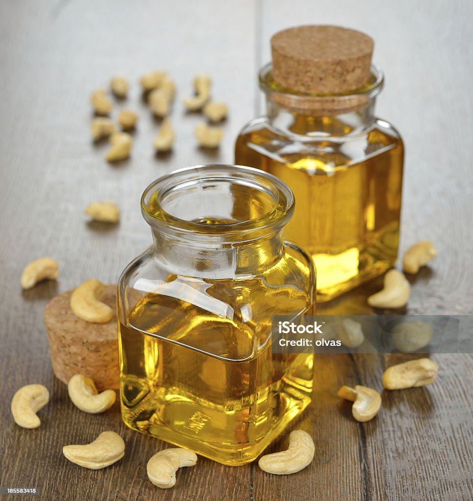 Oil from cashew Oil from cashew  in a glass bottle on a brown background Bottle Stock Photo