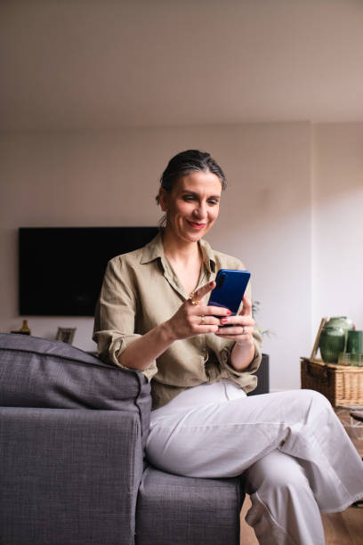 istock Casual businesswoman using phone sitting on the sofa 1855834653