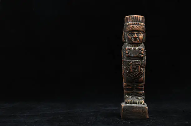 One Ancient Mayan Statue on a Black Background