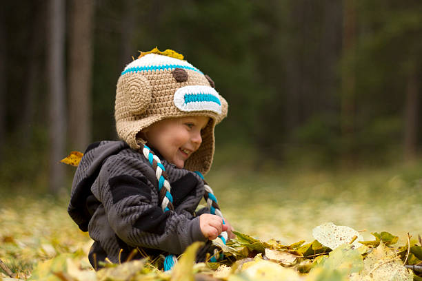 istock Happy baby boy plays in autumn leaves 185589341