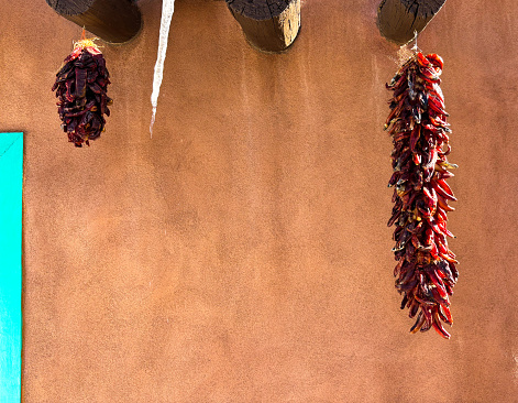 Santa Fe, NM: Adobe wall, two ristras, icicle. Copy space available.