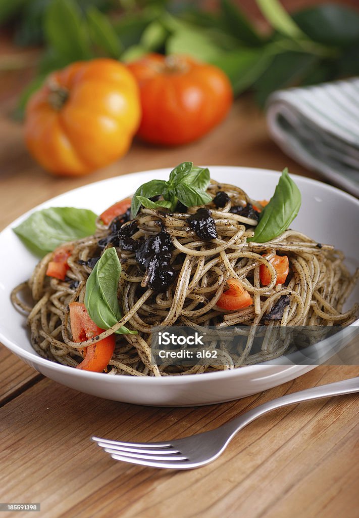 spaghetti with squid ink spaghetti with squid ink and fresh tomatoes Basil Stock Photo