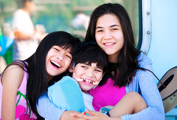 istock Two sisters taking care of disabled little brother 185594724