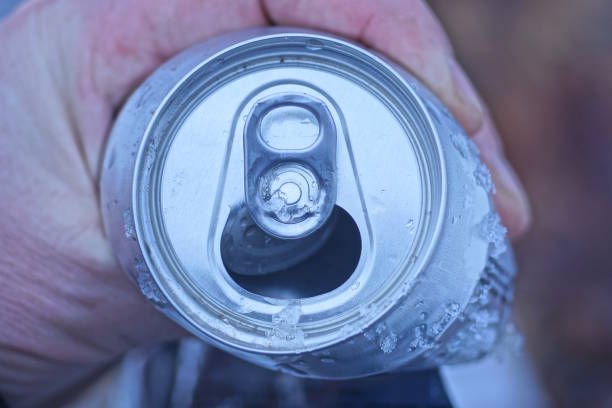 istock hand holding one crumpled open white aluminum beer can 1855948483