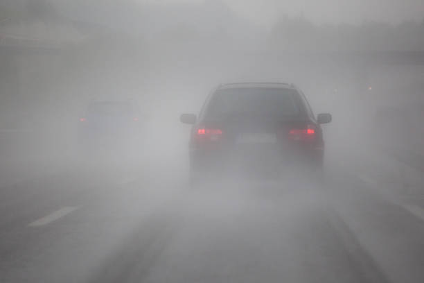 mit dem auto im nebel - nebel stock-fotos und bilder