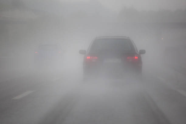 driving car in the fog driving car on the motorway with heavy rain and fog tail light stock pictures, royalty-free photos & images