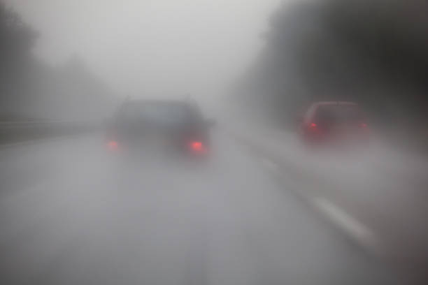 driving cars on a motorway with heavy rain and fog