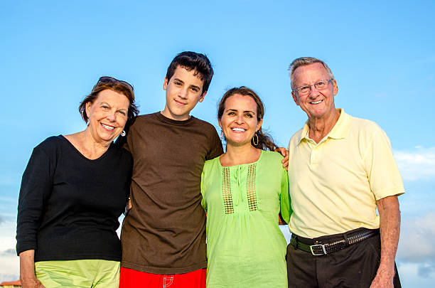 Three generations Grandparents, daughter and grandchild posing happily on a family day on the beach grandmother real people front view head and shoulders stock pictures, royalty-free photos & images