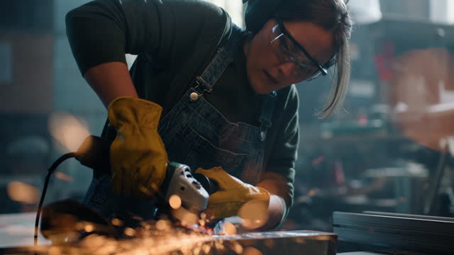 Woman, angle grinder and metal or tool for manufacturing steel, polish product or grinding. Female person, safety gear and industrial power job in welder warehouse or spark light, labor or protection