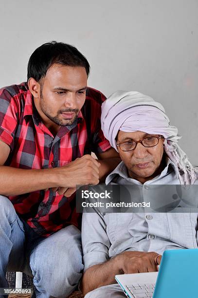 Rural Homem Usando Laptop Com Seu Filho - Fotografias de stock e mais imagens de 70 anos - 70 anos, Adulto, Aldeia