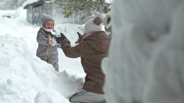 istock Winter family fun in deep snow. Mom and kid play. 1856036765