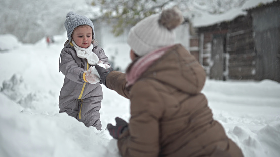 Happy childhood. Family time in winter, playing and laughing in the first snow.