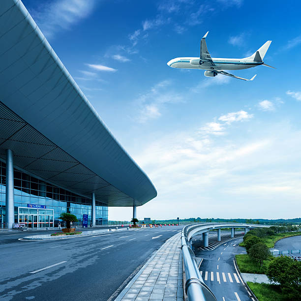 istock Airplane flying low over airport building on a cloudy day 185610320