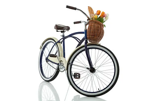 Beach cruiser with basket that has tulips and bread in it isolated on white front view