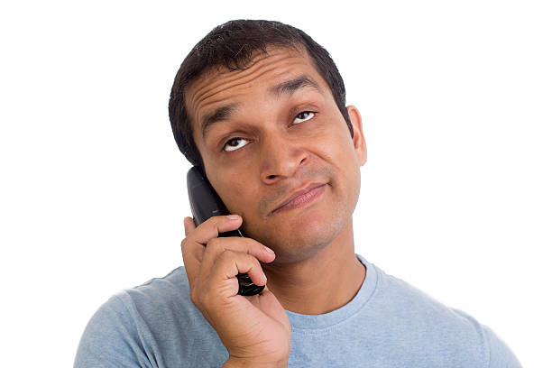 Indian Annoyed and bored at Phone on Hold again…! Indian Man Annoyed and bored at Phone on Hold again…! waiting telephone on the phone frustration stock pictures, royalty-free photos & images