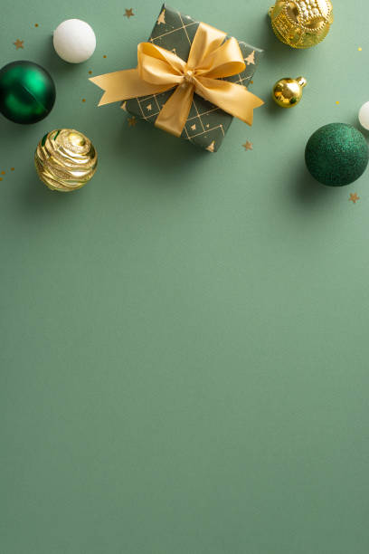 istock Upscale Yuletide setting. Overhead vertical capture of gift wrapped with ribbon, luxurious baubles, gold sequins arranged on mint green backdrop, leaving space for personalized wishes or adverts 1856234465