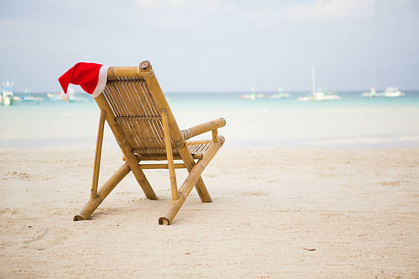 istock Santa hat on chaise longue at white sand beach 185624423