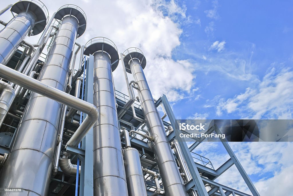 Looking up at chemical plant stacks Chemical plant against blue sky Chemical Plant Stock Photo