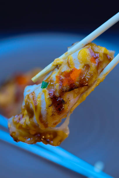 istock Sushi with grilled beef and sauce being held with chopsticks. 1856275789