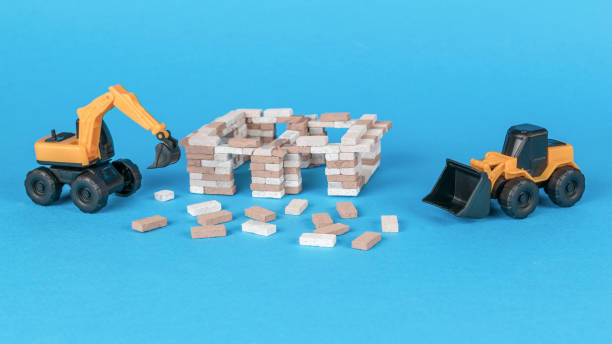 istock An excavator and a bulldozer near a house under construction on a blue background. 1856288866