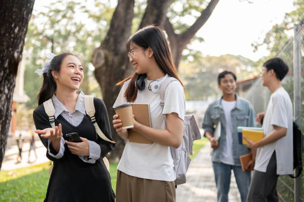 istock Two young Asian female students are enjoying talking while walking on a footpath on their campus. 1856306403