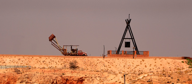 A mining monument in the desert landscape of the opal mining town of Coober Pedy in the arid climate of outback Australia