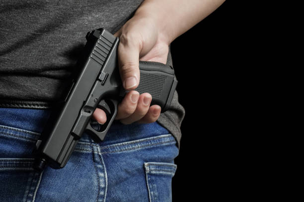 istock Man drawing a conceal carry pistol from a holster 1856375612