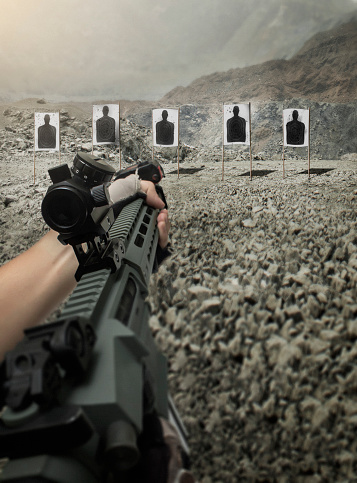 POV of hand aiming and shooting assault rifle at shooting range
