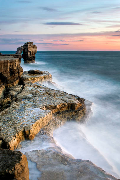 Sunset at Pulpit Rock A stunning autumn sunset at Pulpit rock on the Isle of Portland with the full force of the English Channel crashing against the rocks. bill of portland stock pictures, royalty-free photos & images