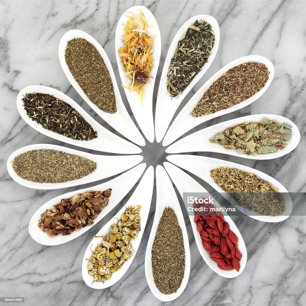 Natural Herbal Teas Herb tea selection in white porcelain dishes over marble background. Alternative Medicine Stock Photo