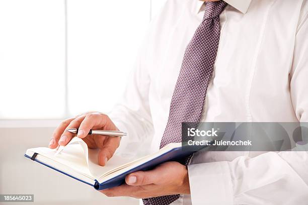Businessman Standing In Office Holding Diary Stock Photo - Download Image Now - Adult, Book, Business