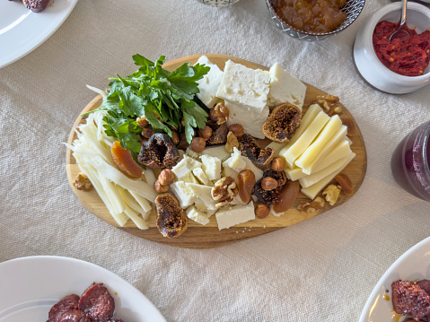 Cheese plate full of delicatessen on a table setting