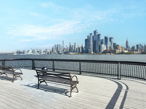 Benches with Manhattan view from Hoboken in New Jersey on a sunny day