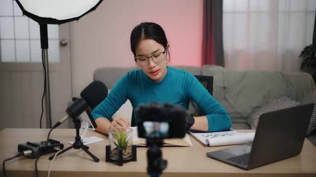 Young asian woman talking during recording video tutorial for internet