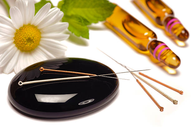 istock Acupuncture needles on a glossy black pebble 185648823