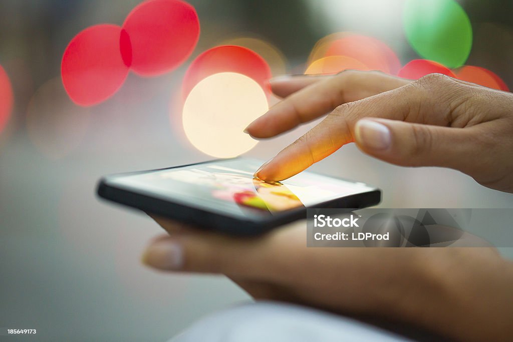 Cell phone with city lights in background Female outdoor mobile phone city sms message night Above Stock Photo