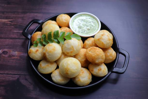 istock Paniyaram are savory balls made using fermented rice and urad dal batter along with tempered onion and spices. Also known as Paddu, Ponganalu, Kuli, bugga, and appe. served with coconut chutney 1856553642