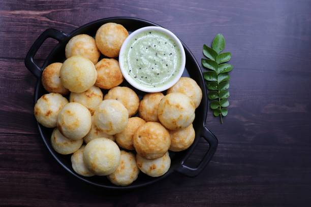 istock Paniyaram are savory balls made using fermented rice and urad dal batter along with tempered onion and spices. Also known as Paddu, Ponganalu, Kuli, bugga, and appe. served with coconut chutney 1856553653