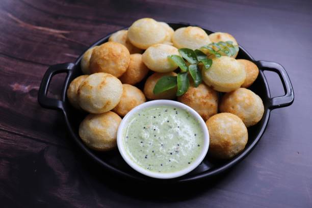 istock Paniyaram are savory balls made using fermented rice and urad dal batter along with tempered onion and spices. Also known as Paddu, Ponganalu, Kuli, bugga, and appe. served with coconut chutney 1856553655