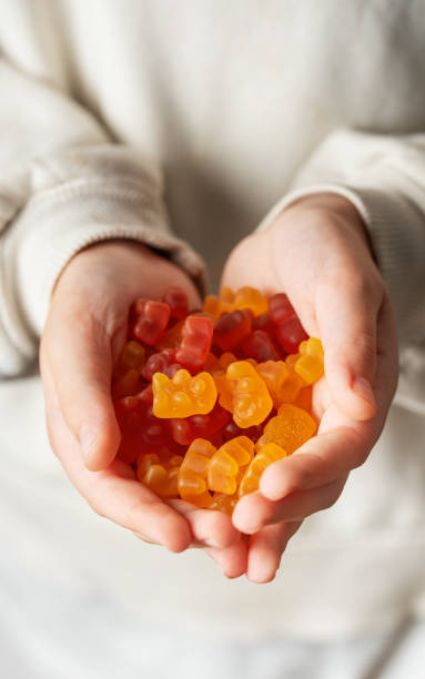 istock A girl holds a gummy bear vitamines in her hands 1856608471
