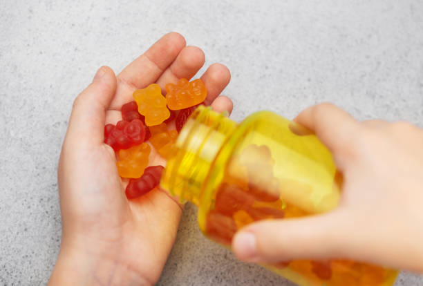 istock A girl holds a gummy bear vitamines in her hands 1856608596