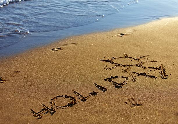 istock Holiday text written in sand on summer beach. 185661267