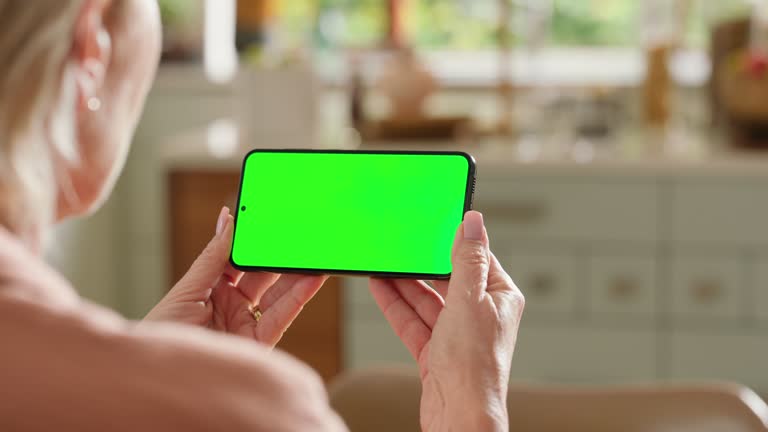 Back of woman, phone or green screen in home for social network notification, download multimedia or subscription. Closeup, mobile and mockup space for digital marketing, streaming news or search web