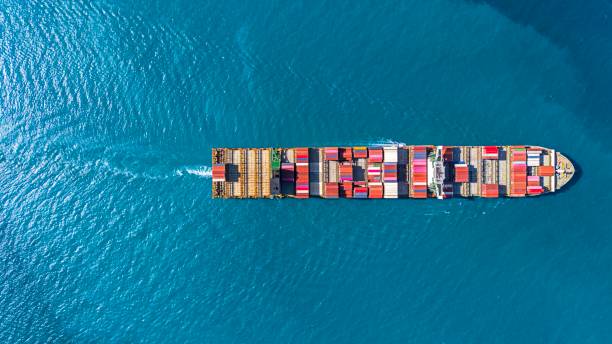 istock Aerial top view cargo container ship, cargo maritime ship with contrail in the ocean ship carrying container and running at blue sea. 1856655912