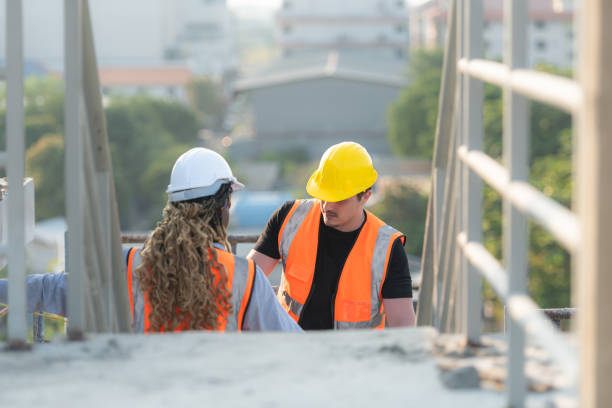 istock Male and female engineers working on construction site, They are inspecting the cement plaster work on the walls and balconies of the building. 1856741076