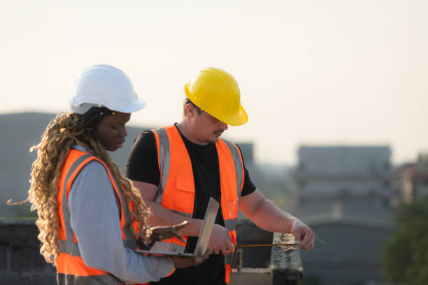 istock Male and female engineers working on construction site, They are inspecting the cement plaster work on the walls and balconies of the building. 1856743241