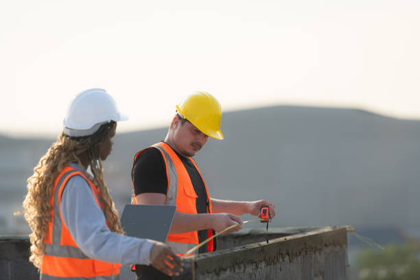 istock Male and female engineers working on construction site, They are inspecting the cement plaster work on the walls and balconies of the building. 1856743764